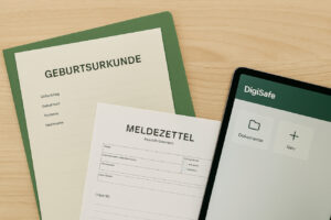 Ein Schreibtisch mit ordentlich abgelegten Dokumenten, darunter eine Geburtsurkunde, ein Meldezettel und ein Tablet mit deutscher Benutzeroberfläche. Das Bild vermittelt Vorsorge, Ordnung und digitale Dokumentensicherung.
